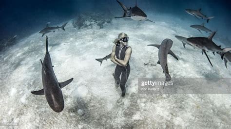 Underwater View Of Female Free Diver Standing On Seabed Surrounded By