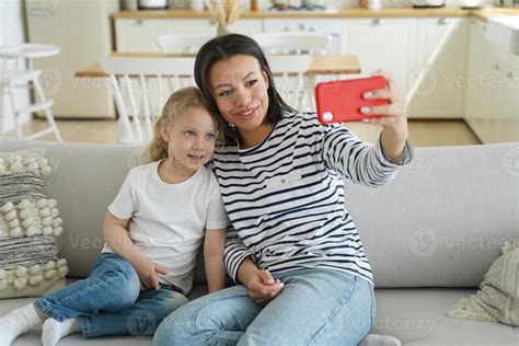 Mom Foster Daughter Use Phone Chat With Father By Videocall Or Take Selfie Sitting On Couch At