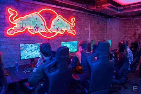 Several People Are Playing Video Games In Front Of The Neon Sign That