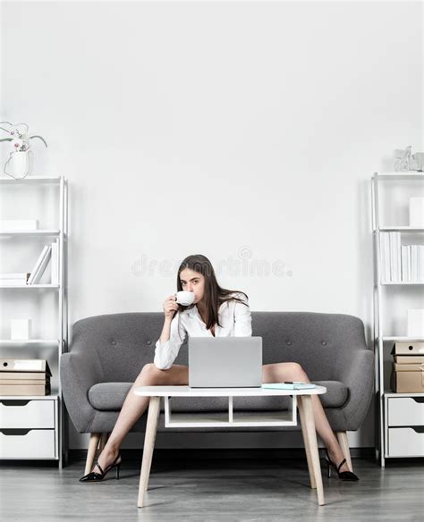 secretaria seductora con piernas sexys sentada en el sofá en la oficina mujer de negocios sexy