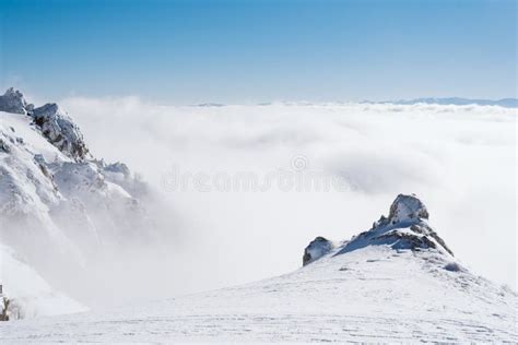 The Summit Of A Snowy Mountain With A Clear Blue Sky On A Sunny Day
