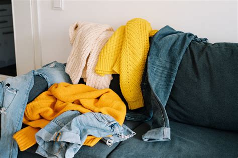 Couch Covered In Messy Clothing Stock Photo Download Image Now