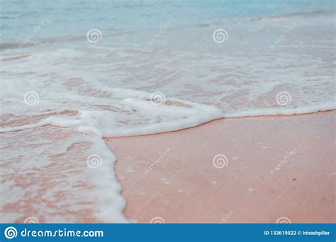 Soft Blue Waves Of The Sea With White Foam On The Sandy Beach Stock