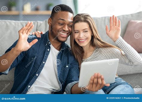 Web Chat Interracial Couple Holding Digital Tablet And Waving Hands At