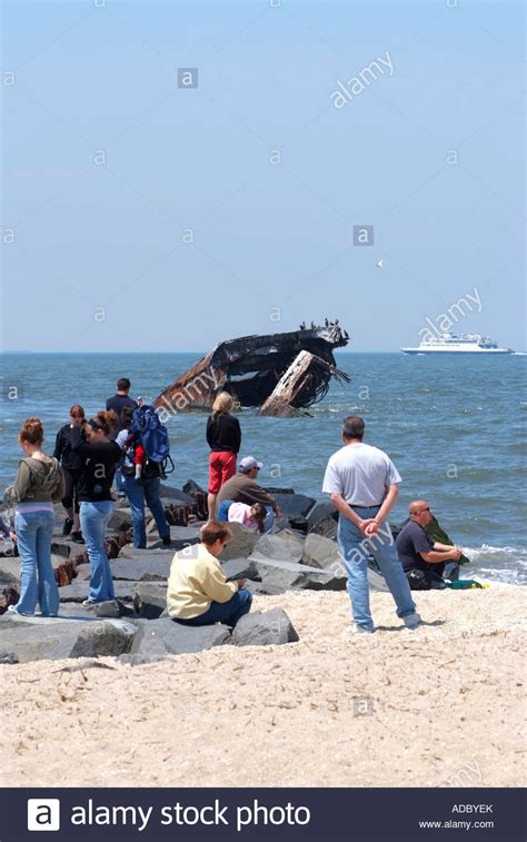 Tourists On Sunset Beach Near Cape May Point With Wreck Of Concrete