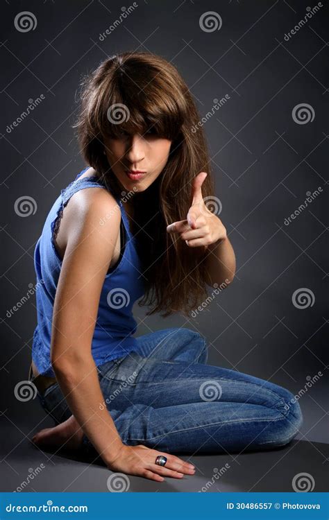 Hübsche Frau In Den Jeans Lächelnd Und Auf Dem Boden Sitzend Lizenzfreie Stockfotografie Bild
