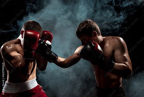 Two Professional Boxer Boxing On Black Smoky Background Stock Photo