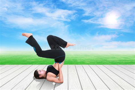 kobieta robi joga ćwiczeniu na drewnianej podłoga z zieloną trawą i niebem obraz stock obraz