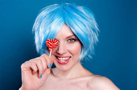 Joyeuse Femme Drôle En Perruque Bleue Avec Une Sucette Dans Les Mains Photo Premium