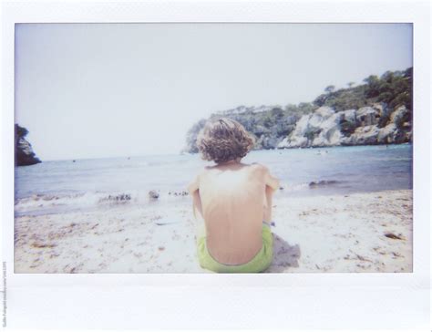 Topless Kid In Swimshorts Sitting On Beach Del Colaborador De Stocksy Guille Faingold Stocksy
