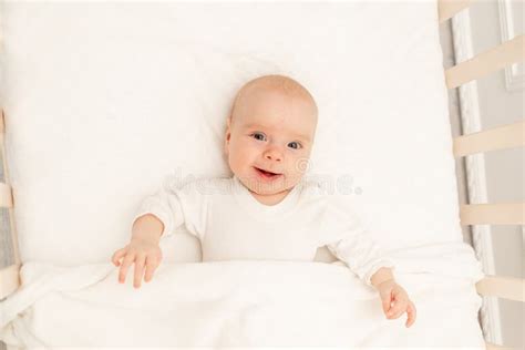 Sleeping Baby And His Toy In White Crib Nursery Interior And Bedding