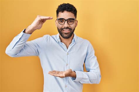 Hispanic Man With Beard Standing Over Yellow Background Gesturing With