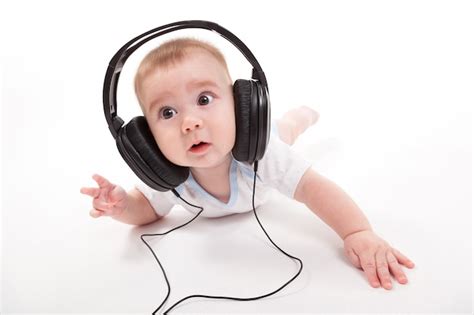 Bebé Encantador Sobre Un Fondo Blanco Con Auriculares Escuchando Foto