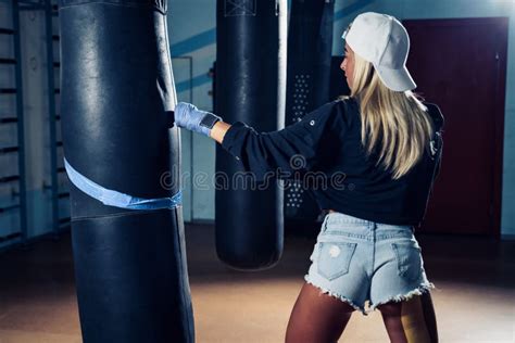 Concentrated Woman Doing A Fitness Boxing Workout With A Punching Bag