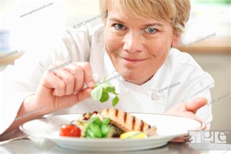 Chef Adding Garnish To Meal In Restaurant Kitchen Stock Photo Picture