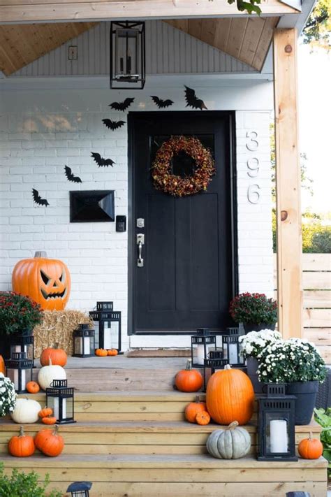 The Front Porch Is Decorated For Halloween With Pumpkins Lanterns And Other Decorations On It