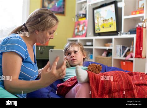 Maman Avec Sa Fille Qui Ne Se Sent Pas Bien En Utilisant Le Téléphone Cellulaire Pour Consulter