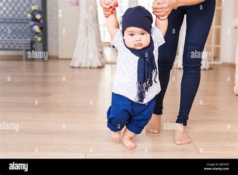 Baby Taking First Steps With Mother Help Stock Photo Alamy