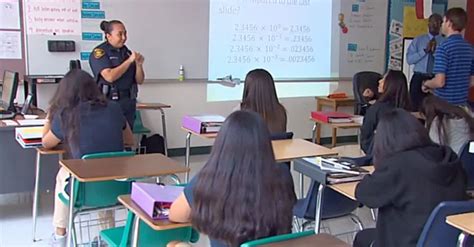 Police Officer Stands In Front Of The Classroom But Students Are