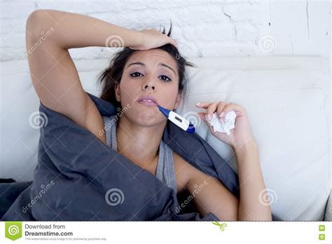 Young Attractive Hispanic Woman Lying Sick At Home Couch In Cold And