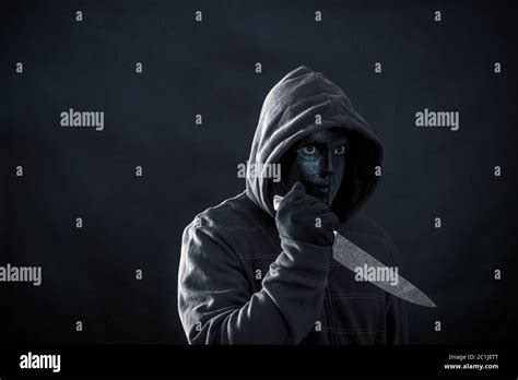 Hooded Man With Black Mask Holding Knife In The Dark Stock Photo Alamy