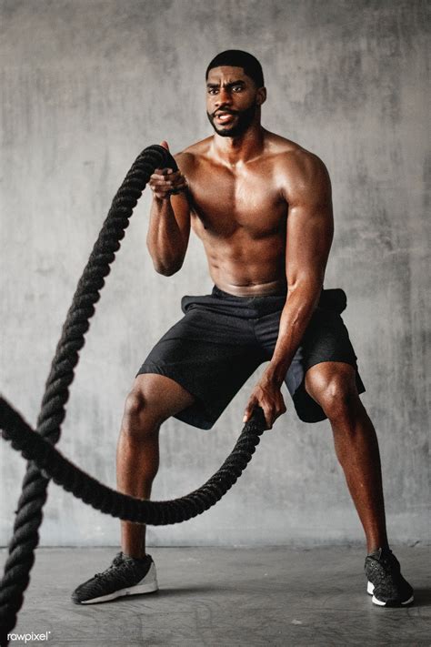 Muscular Man Working Out On The Battle Ropes In A Gym Premium Image