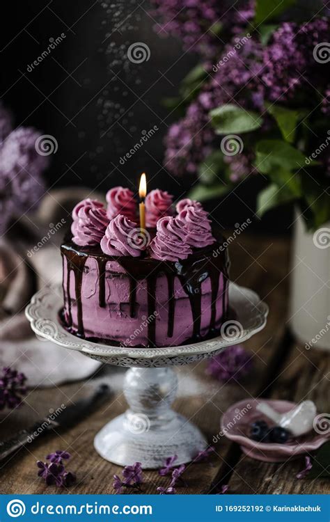 On The Table Is A Beautiful Chocolate Cake And A Bouquet Of Lilacs