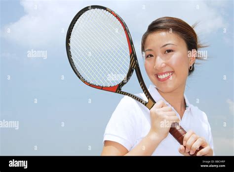 Young Woman Holding Tennis Racket Smiling At Camera Stock Photo Alamy