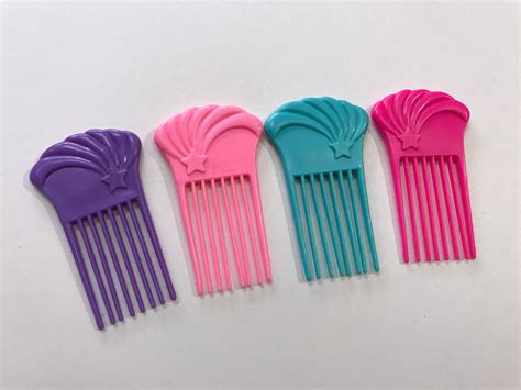 Four Different Colored Combs Sitting Next To Each Other