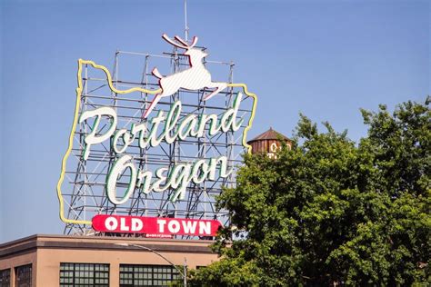 An Old Town Sign On The Top Of A Building In Portland Oregon With A Deer