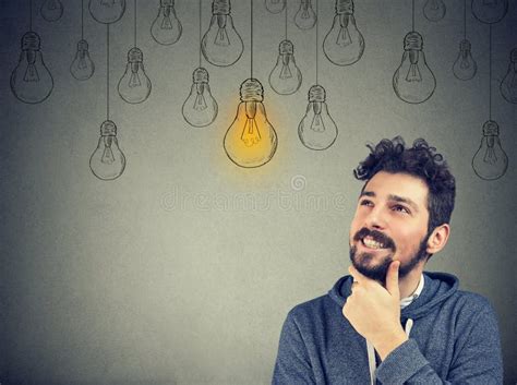Thinking Man Smiling Looking Up At Light Idea Bulb Above Head Stock