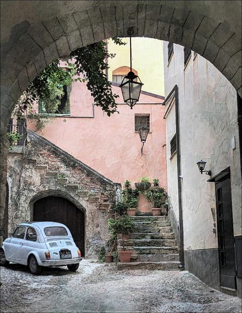 blue vintage car under an arch in cefalu sicily photograph by toni abdnour fine art america