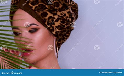 An Attractive Young Woman In A Stylish Turban Made Of Leopard Print
