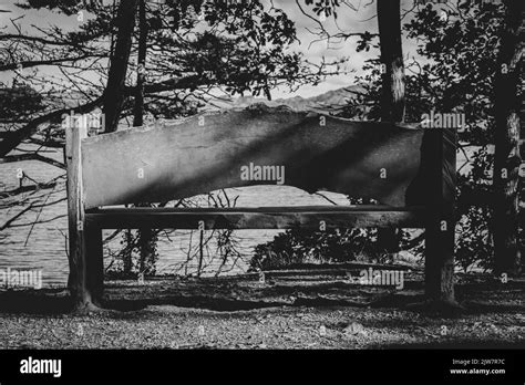 black and white image of a bench with the perfect view over penrose national trust lake stock