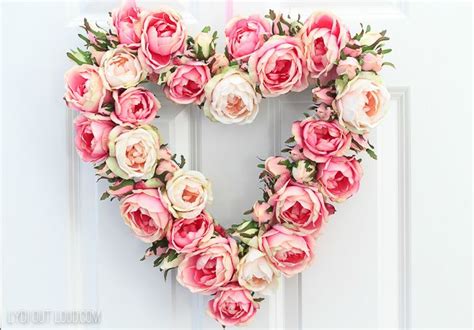 A Heart Shaped Wreath With Pink And White Flowers Hanging On The Front