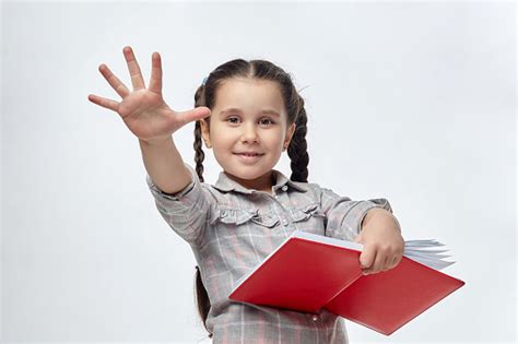 Little Blackhaired Girl Holds A Red Book In Her Hands And Shows A Palm
