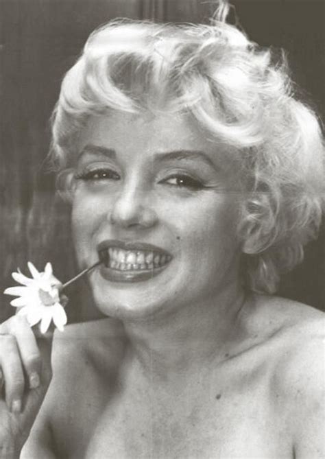 Marilyn Monroe Smiling And Holding A Flower In Her Mouth