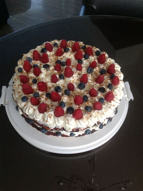 A Cake With White Frosting And Berries On It