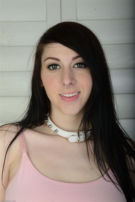 A Woman With Long Black Hair Wearing A Pink Tank Top And White Choker Necklace