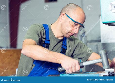 Worker In Factory On Work Bench With Hammer Stock Photo Image Of