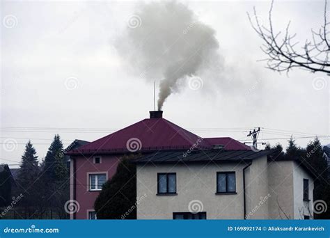 Black Smoke Comes From Chimney Of A House Against Gray Sky Heating
