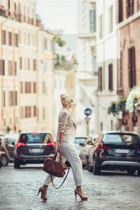 elegant blonde businesswoman crossing the street by stocksy contributor lumina stocksy