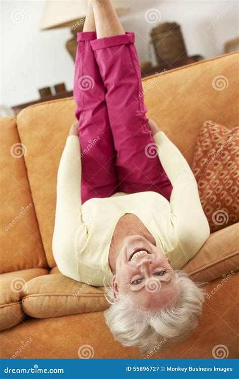 Senior Woman Lying Upside Down On Sofa At Home Stock Image Image Of
