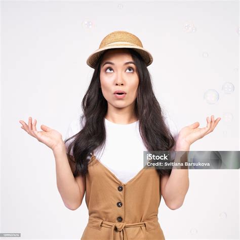 A Young Asian Girl Spreads Her Arms To The Sides And Looks Up Stock