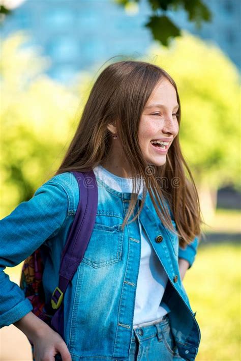 Girl Schoolgirl Summer In Nature In Denim Jacket Behind A Backpack Happy Smiling Returns Home