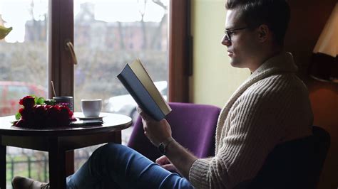 Man Reading Book And Drinking Coffee In The Restaurant Stock Video