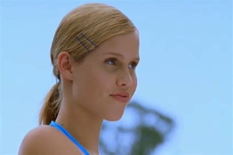 A Close Up Of A Person Wearing A Blue Tank Top And Hair In A Ponytail
