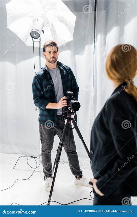 Handsome Young Photographer Standing With Camera And Looking At