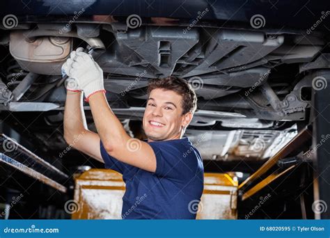 Smiling Mechanic Working Underneath Lifted Car Stock Image Image Of