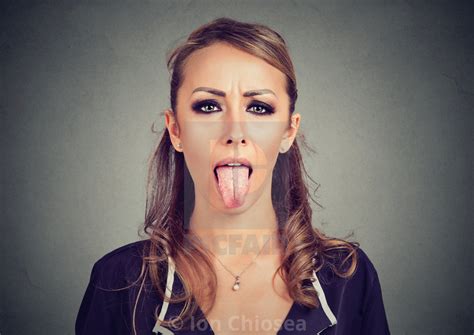 Closeup Portrait Of A Woman Sticking Her Tongue Out License Download